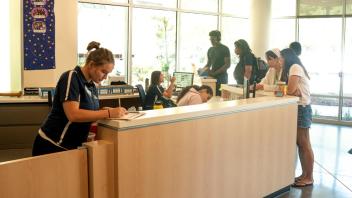 Students working at the Cuarto residence hall service desk